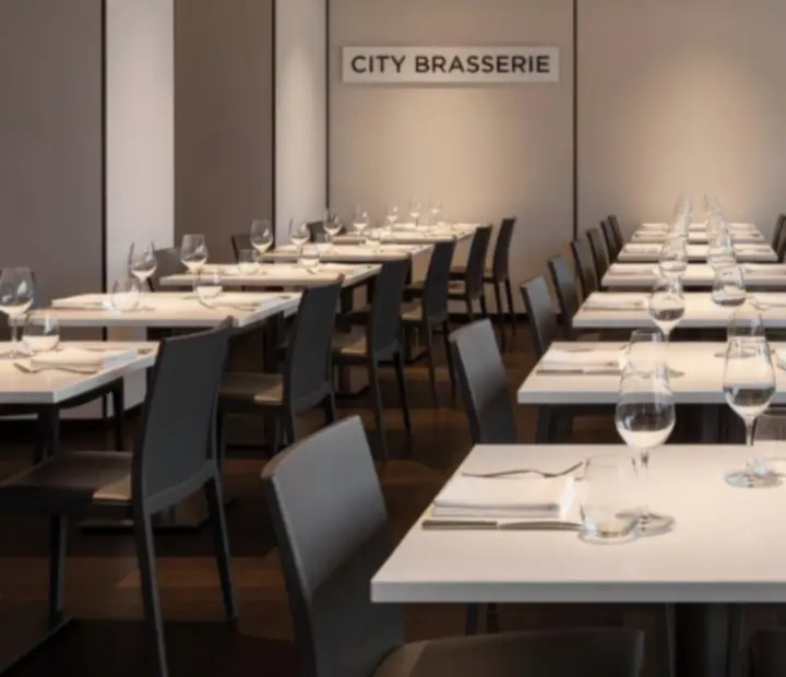 APARTAMENT SZRENICA dining room arranged in a strict grid of white tablecloths and graphite chairs